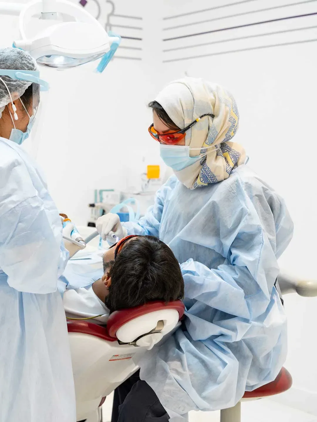 A general dentist at Harmony Medical Center examines patient's mouth checking for cavities or the need for dental fillings.
