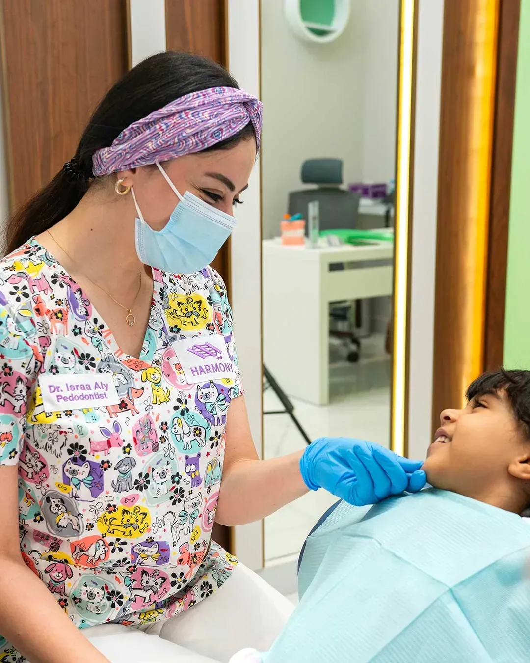 Pediatric dentist at Harmony Medical Center caring for a young child seated in the dental chair.